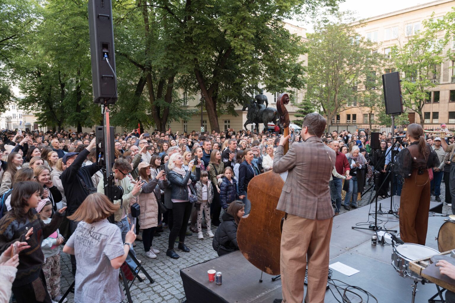 muzycy na scenie, duża grupa ludzi tańczy