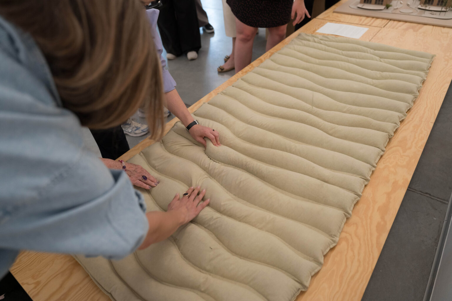 dłonie dotykające obiekt w postaci pofałdowanego materiału