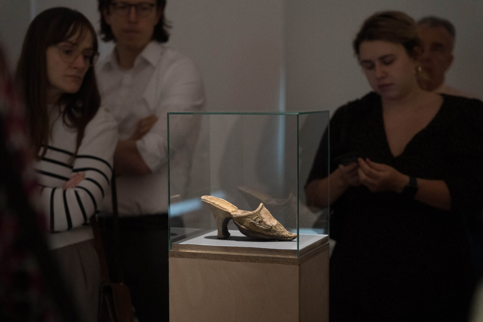 obiekt - czułenko w szklanej gablocie, osoby wokół niego