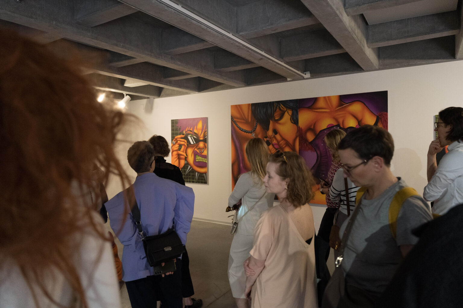 duża grupa zwiedzających wystawę w przestrzeni galerii z obrazami dużych rozmiarów na ścianach