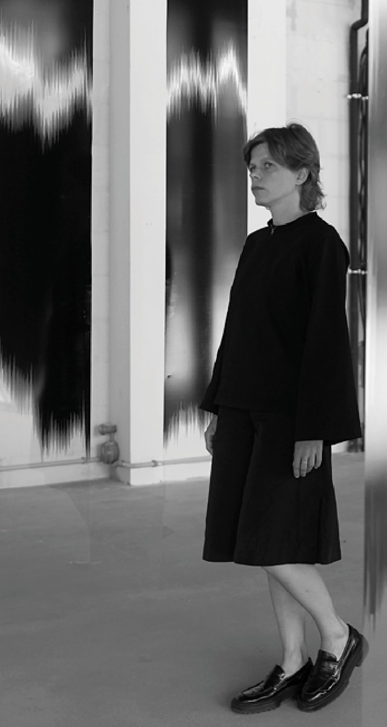 czarno-białe pionowe zdjęcie kobiety w czarnej sukience i mokasynach