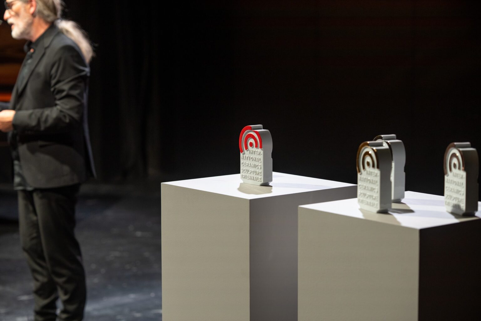 dwie ceramiczne statuetki na podestach