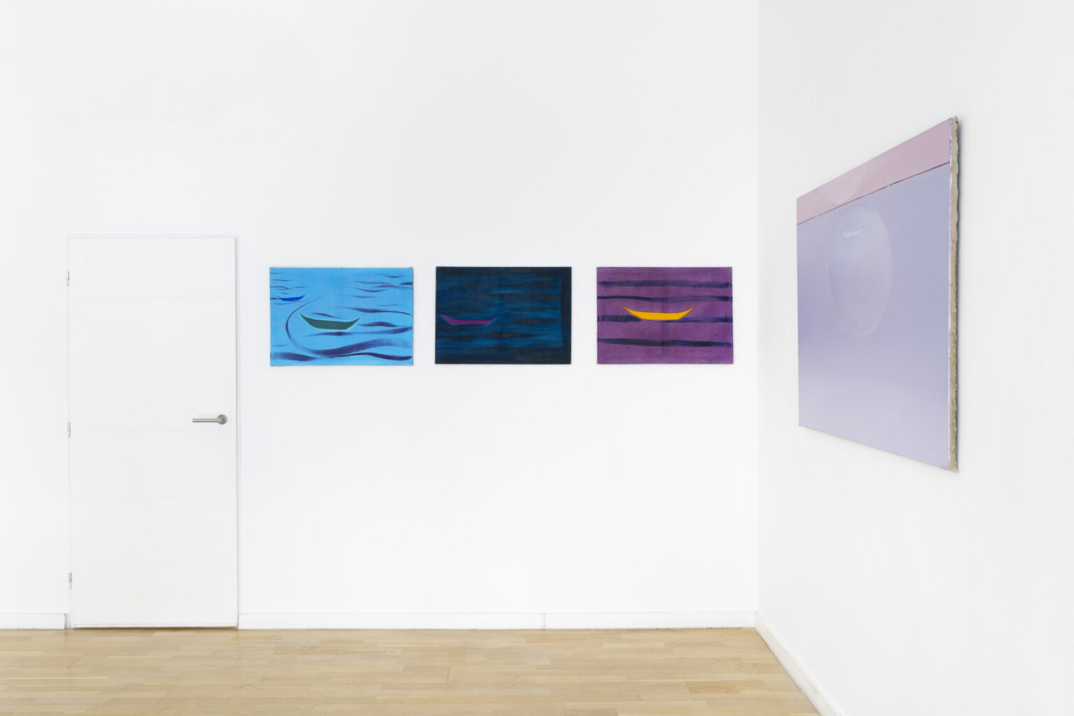 trzy obrazy na ścianie w przestrzeni wystawy przedstawiające łódki