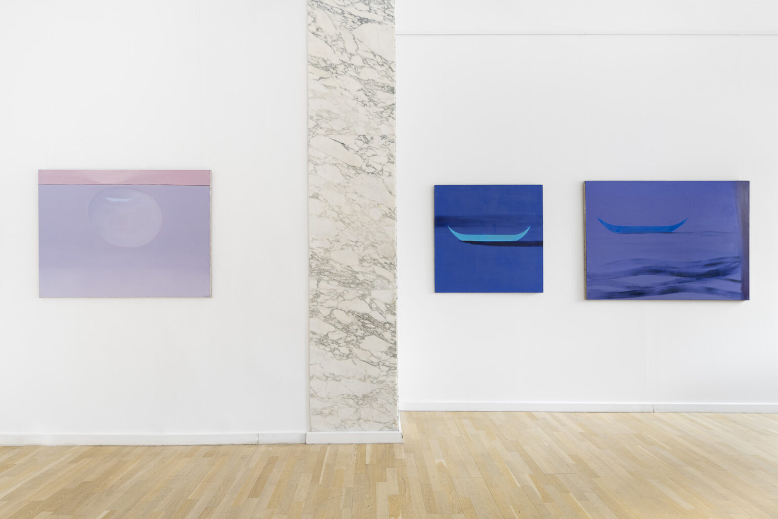 trzy obrazy na ścianie w przestrzeni wystawy, dwa po prawej stronie przedstawiają łódki