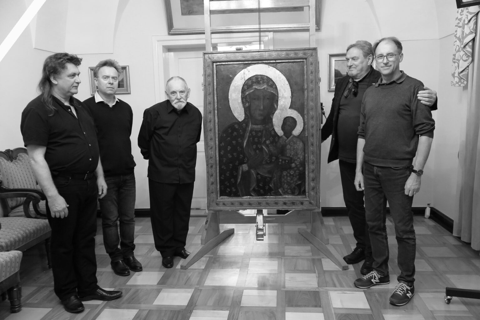 Czarno-białe zdjęcie 6 mężczyzn pozujących z ikoną Matki Boskiej Ostrobramskiej.