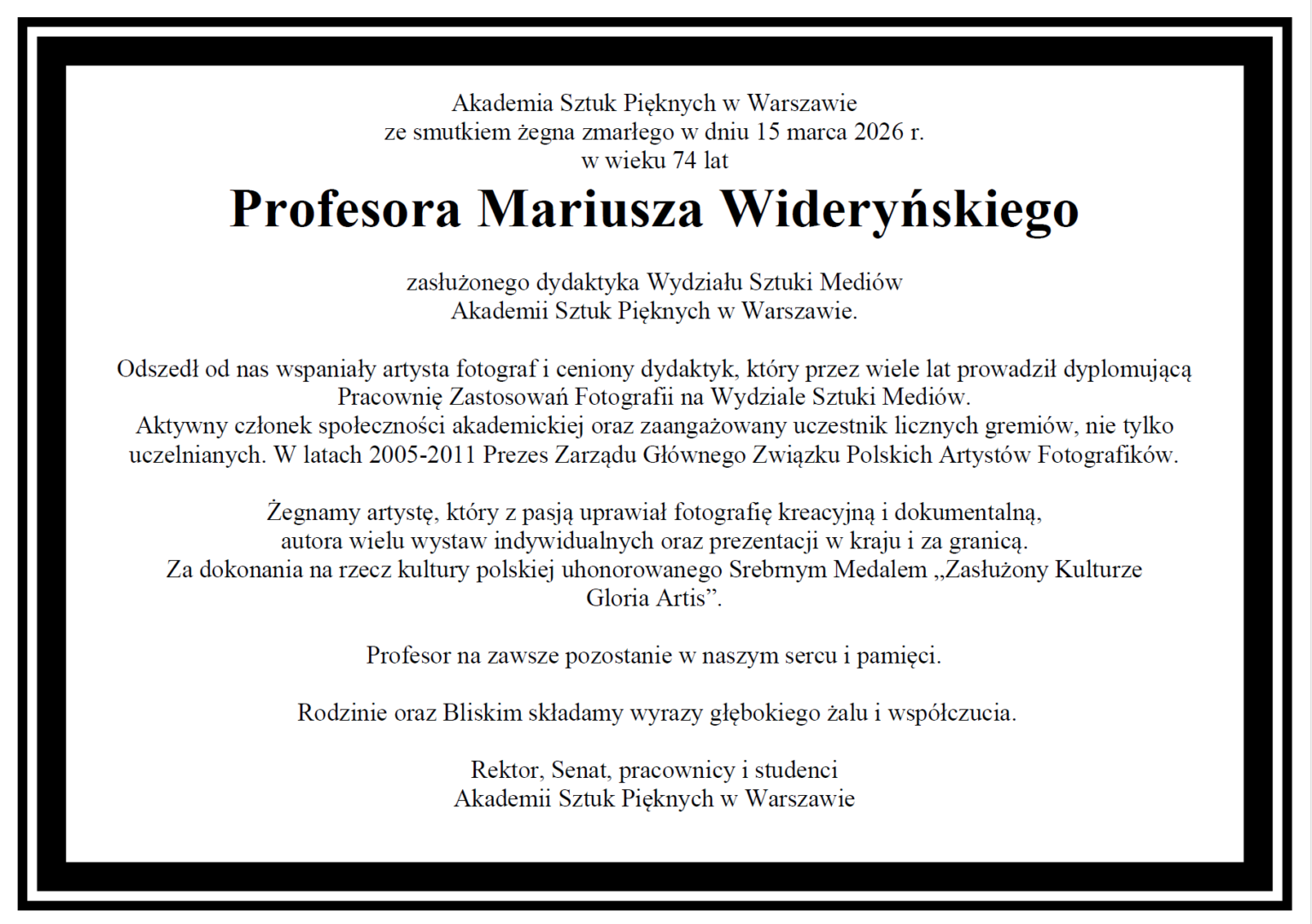 Czarno-biały portret mężczyzny w okularach i ciemnej koszulce polo, z lekkim uśmiechem na twarzy.